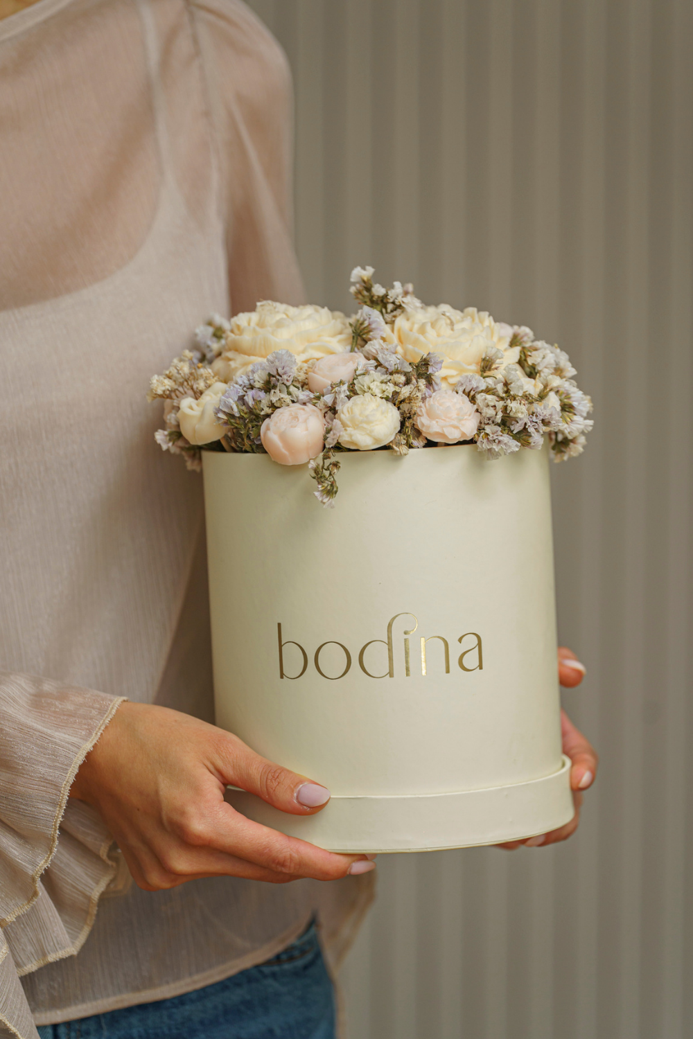 Nuestros Bouquets Bodina reimaginan los arreglos florales desde el arte y la sensibilidad. Cada ramo está compuesto por velas esculpidas —rosas, tulipanes, margaritas y más— elaboradas con cera de soya 100% natural, color marfil y un delicado aroma a coco y vainilla.